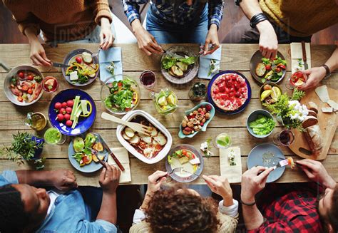Group Of Young People Eating Dinner Stock Photo Dissolve