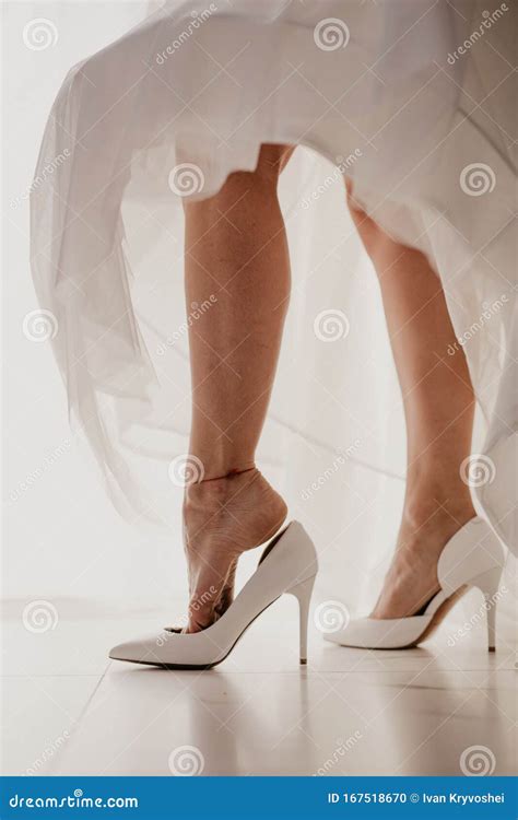 Bride Wearing High Heel Shoe On Mirror Floor Near Panoramic Window On