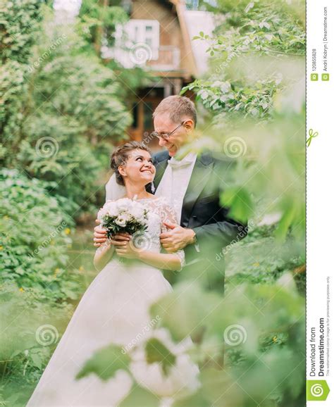 Cheerful Hugging Newlywed Couple In The Green Garden Stock Photo