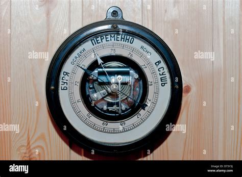 Antique Russian Wall Mounted Barometer On A Wood Panel Wall Stock Photo