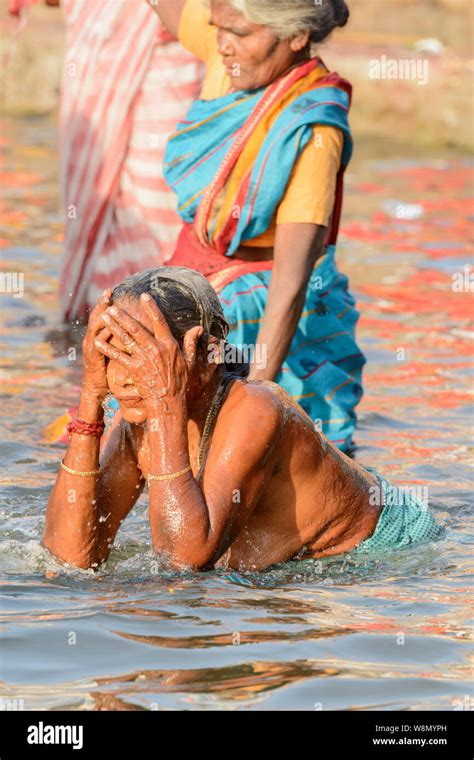 Indian Hindu Women Wearing Saris Perform Early Morning Bathing Rituals In The River Ganges In