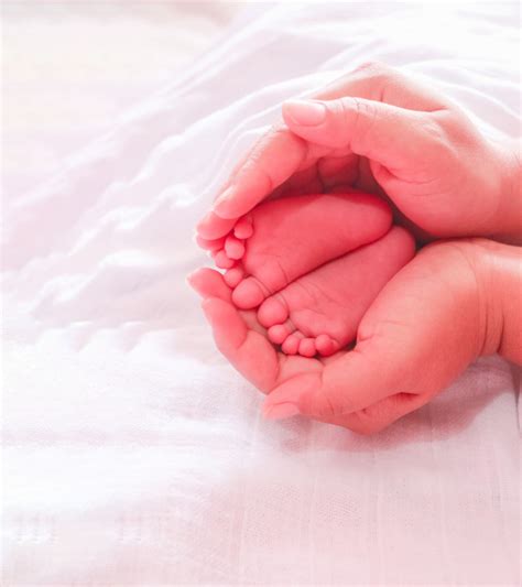 Premium Photo Mother Hands Holding Infant Feet Sleeping
