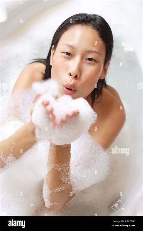 Woman In Bathtub Blowing Soap Suds At Camera Stock Photo Alamy