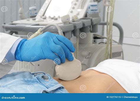 Doctor Conducting Ultrasound Examination Of Patient`s Abdomen In Clinic