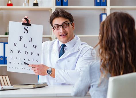 Doctor Optician With Letter Chart Conducting An Eye Test Check Stock