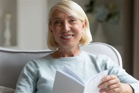 Portrait Of Smiling Mature Woman Reading Book At Home Stock Image Image Of Enjoy Camera