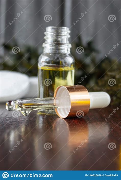Essential Oil Drops From A Glass Dropper On The Table Stock Photo