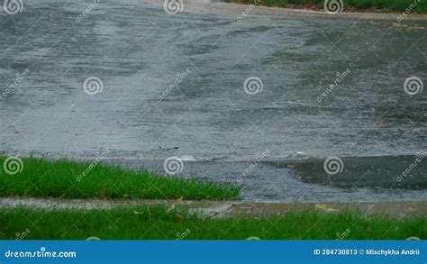 Slow Motion Shot Heavy Rain Water Drops Falling Into Big Puddle On Asphalt Flooding The Street