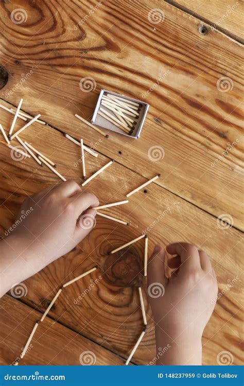 A Boy Playing With Matchsticks Young Kid Plays Match Sticks On Wooden