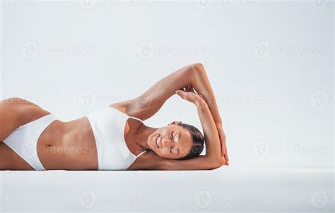 Lying Down On The Floor Beautiful Woman With Slim Body In Underwear Is In The Studio