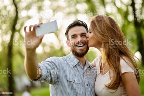 Young Affectionate Couple Taking Selfie In The Public Park Stock