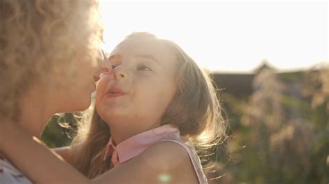 Close Up Of Happy Daughter Rubbing Noses With Mother Kissing Parent In