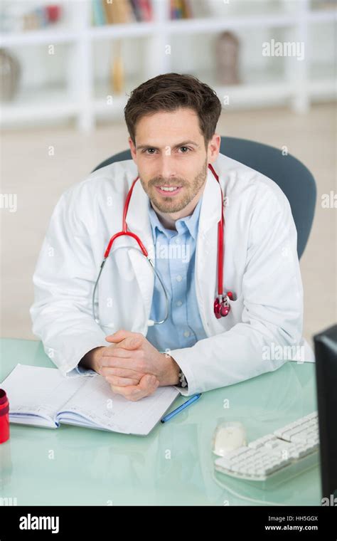 Doctor Sitting At Desk Stock Photo Alamy