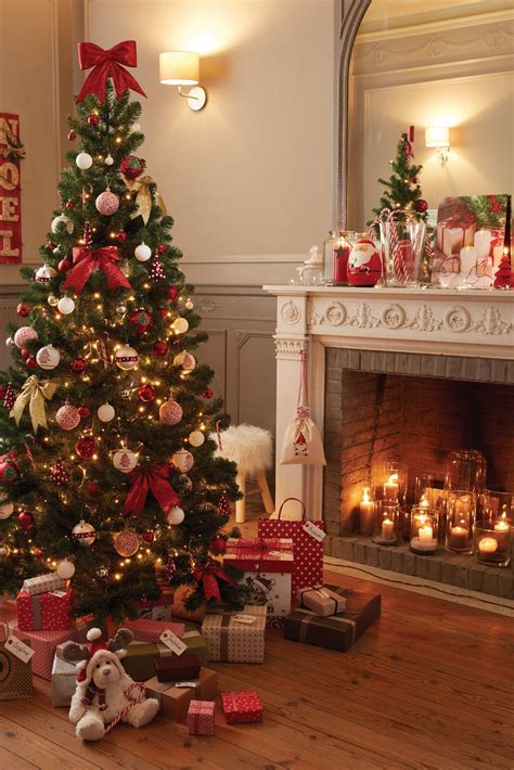 A Decorated Christmas Tree In Front Of A Fireplace With Presents On The