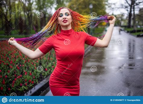 Cute Girl With Multi Colored African Braids And Bright Expressive Makeup In A Tight Red Dress Is