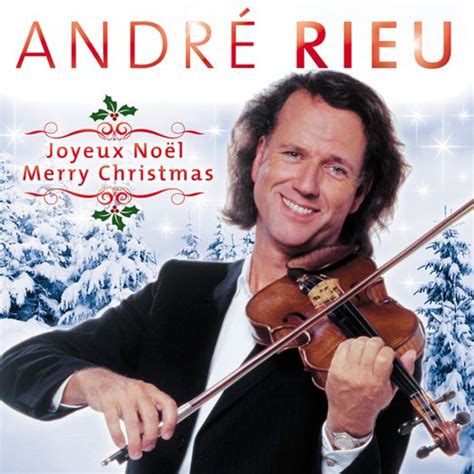 A Man Holding A Violin In His Right Hand And Smiling At The Camera With Snow Covered Trees