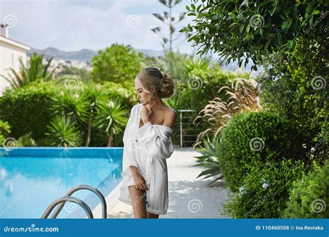 belle sexy sensuelle et chaude fille modèle blonde dans le peignoir posant la demi piscine