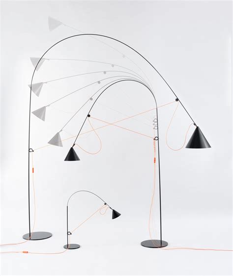 Three Black And White Floor Lamps With Orange Cords Attached To Them