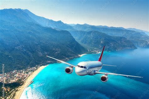 Stockfoto Airplane Is Flying Over Amazing Mountains With Forest And Sea