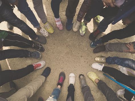 Top View Of Feet Of People Standing In A Circle Runners Standing In A Huddle With Their Feet