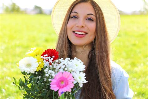 Gorgeous Young Woman Holds Bouquet Of Flowers And Looks At Camera In A