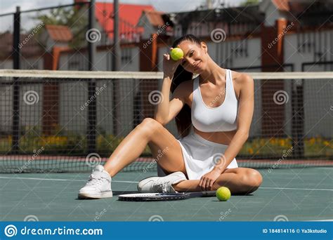 Alluring Adult Woman Sitting On Tennis Court In Sunlight Stock Photo