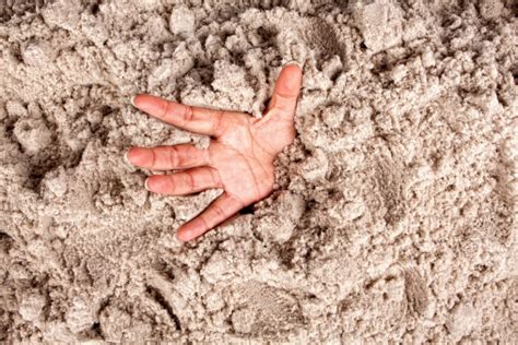 Close Up Of A Hand Coming Out Of Deep Sand Stock Photo Download Image