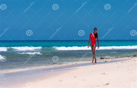 Portrait Of Beautiful Caribbean Adult Teen In Barbados Wearing Red Bikini And Walking On A