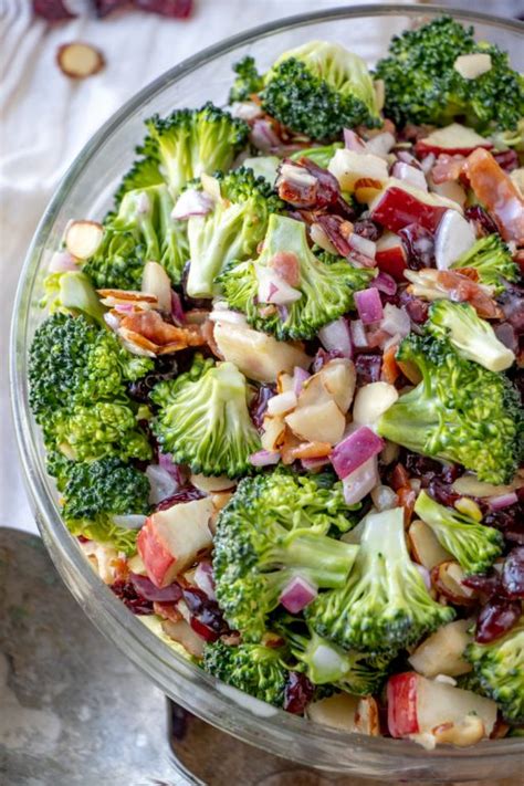 In a large glass bowl combine broccoli florets, cup shredded carrots, diced red onion, sliced celery, chopped pink lady apples, dried cranberries, raisins, and sunflower seeds. Bacon and Apple Broccoli Salad | Wishes and Dishes