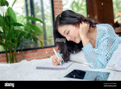 Girl In Casual Dress Writing Diary Or Studying In Bed Thinking Stock
