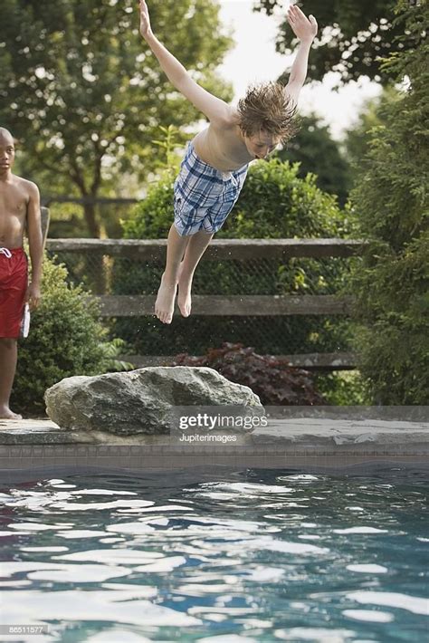 Boy Jumping Into Swimming Pool High Res Stock Photo Getty Images