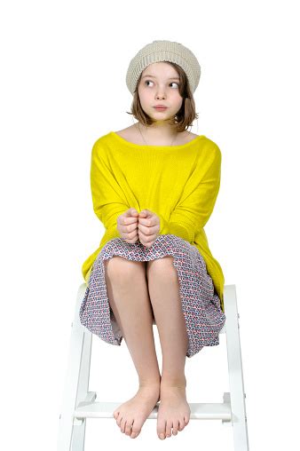 Barefoot Girl Sitting On A Stepladder With A Mysterious Look Stockfoto