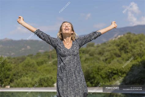 Happy Woman With Arms Outstretched Standing In Mountains — Vacations
