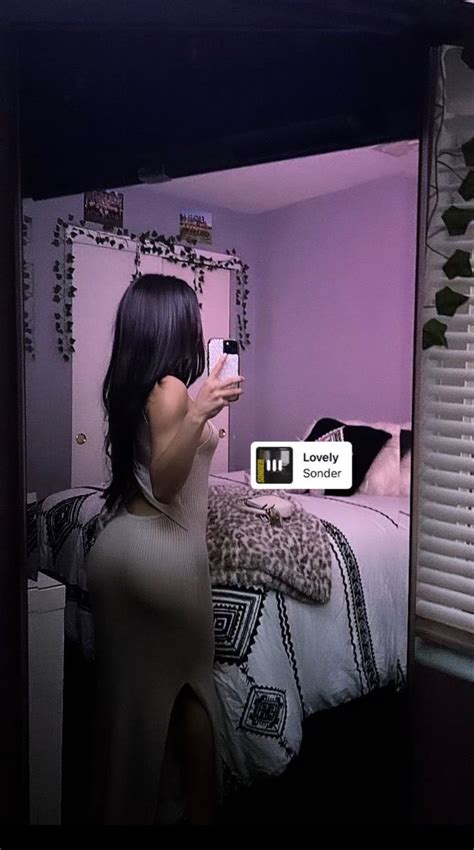 a woman taking a selfie with her cell phone in a bedroom at night time