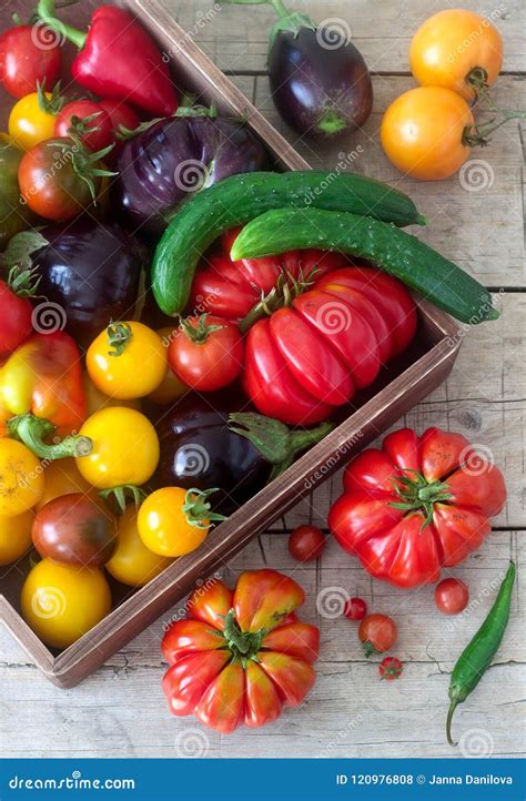 Fresh Vegetables On A Wooden Surface Tomatoes Peppers Cucumbers And