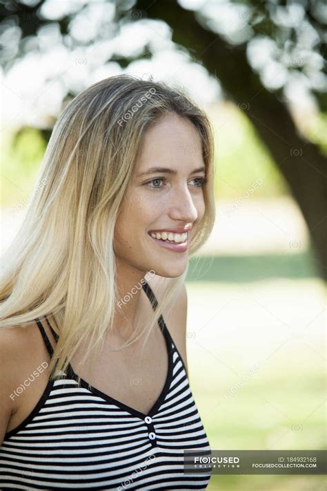 Portrait Of Smiling Blonde Woman Looking Away Outdoors — Person 20 25