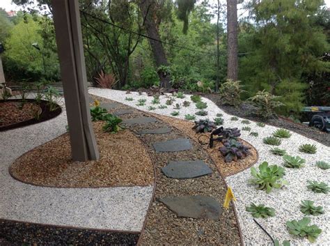 A Garden With Rocks Gravel And Plants In The Foreground Is An Outdoor