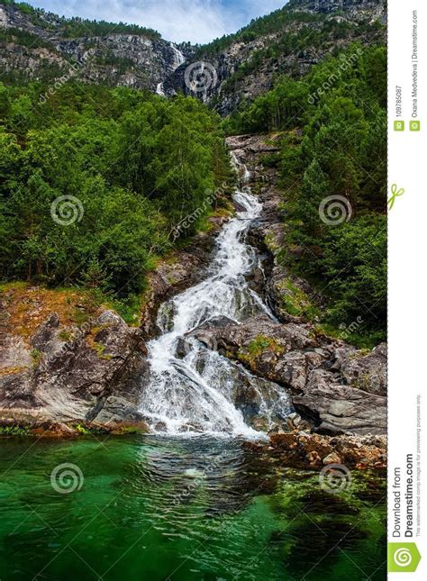 Mountain Landscape With A Beautiful Waterfall And Cloudy Sky