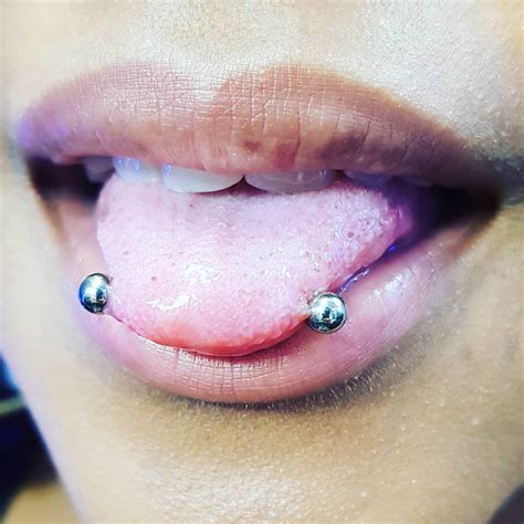 Snake eyes piercing (horizontal tongue piercing) is a double perforation on the tip of the tongue in which a barbell horizontally goes through the tongue. Snake Eyes Piercing - Piercing Studio Wien