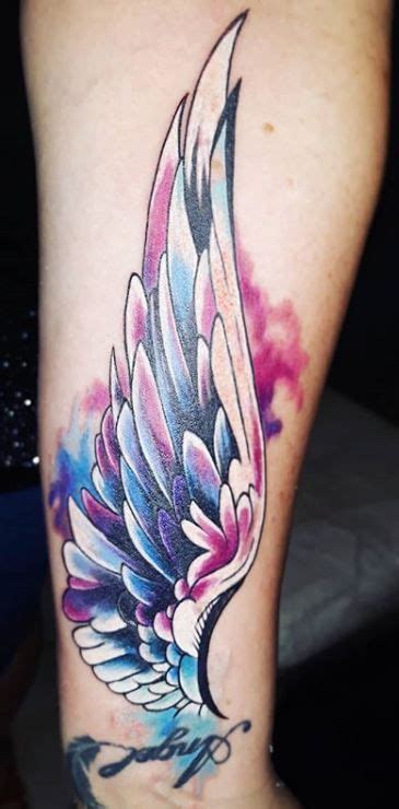 A Colorful Tattoo On The Leg Of A Womans Leg With An Angel Wing