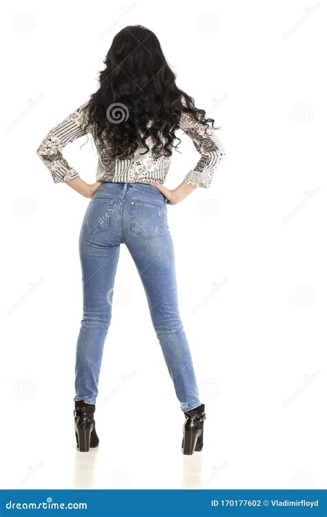Back View Of Attractive Woman In Jeans Posing On White Stock Photo
