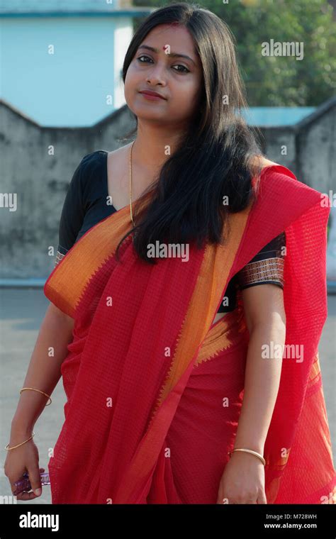 Beautiful Bengali Lady Is Standing On A Rooftop Wearing A Red Saree