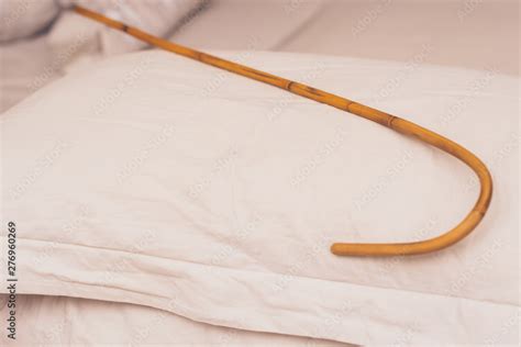 stockfoto rattan cane prepared for spanking on pillow domestic discipline traditional corporal