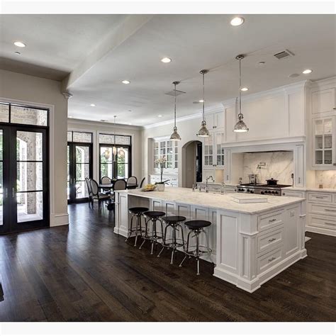 This lovely wooden kitchen has a dark hardwood floor that matches the beautiful colors in. Love the contrast of white and dark wood floors! By Simmons Estate Homes | White kitchen design ...
