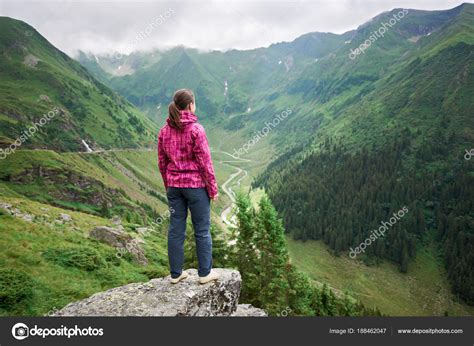 Female Tourist Enjoys The Beautiful Scenery Of The Valley Of Green Mountains Clouds Hanging
