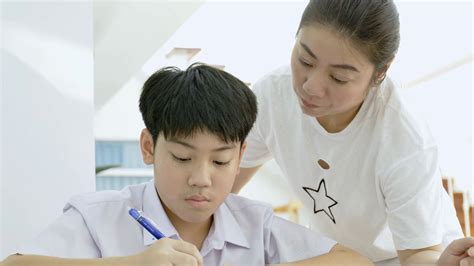 Slow Motion Of Asian Mother Helping Her Son Doing Homework On White