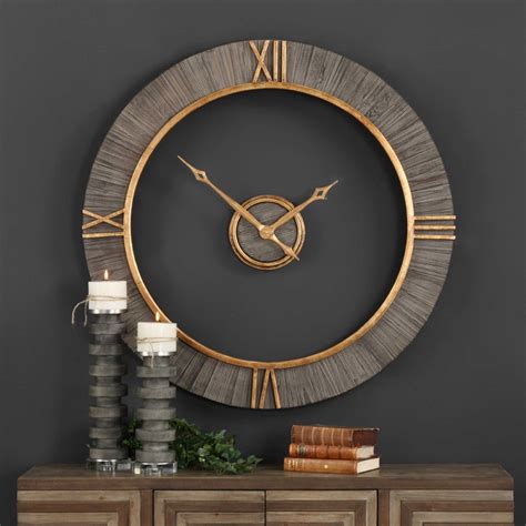 A Large Clock On The Wall Above A Table With Two Candles And Some Other Items