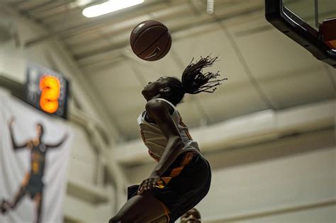 A Basketball Player In The Air With A Ball In The Air Premium Ai