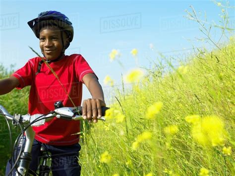 Boy Biking In Field Of Flowers Stock Photo Dissolve