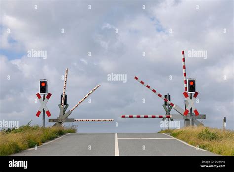 Railroad Crossing With Gates In Motion And Traffic Lights Germany